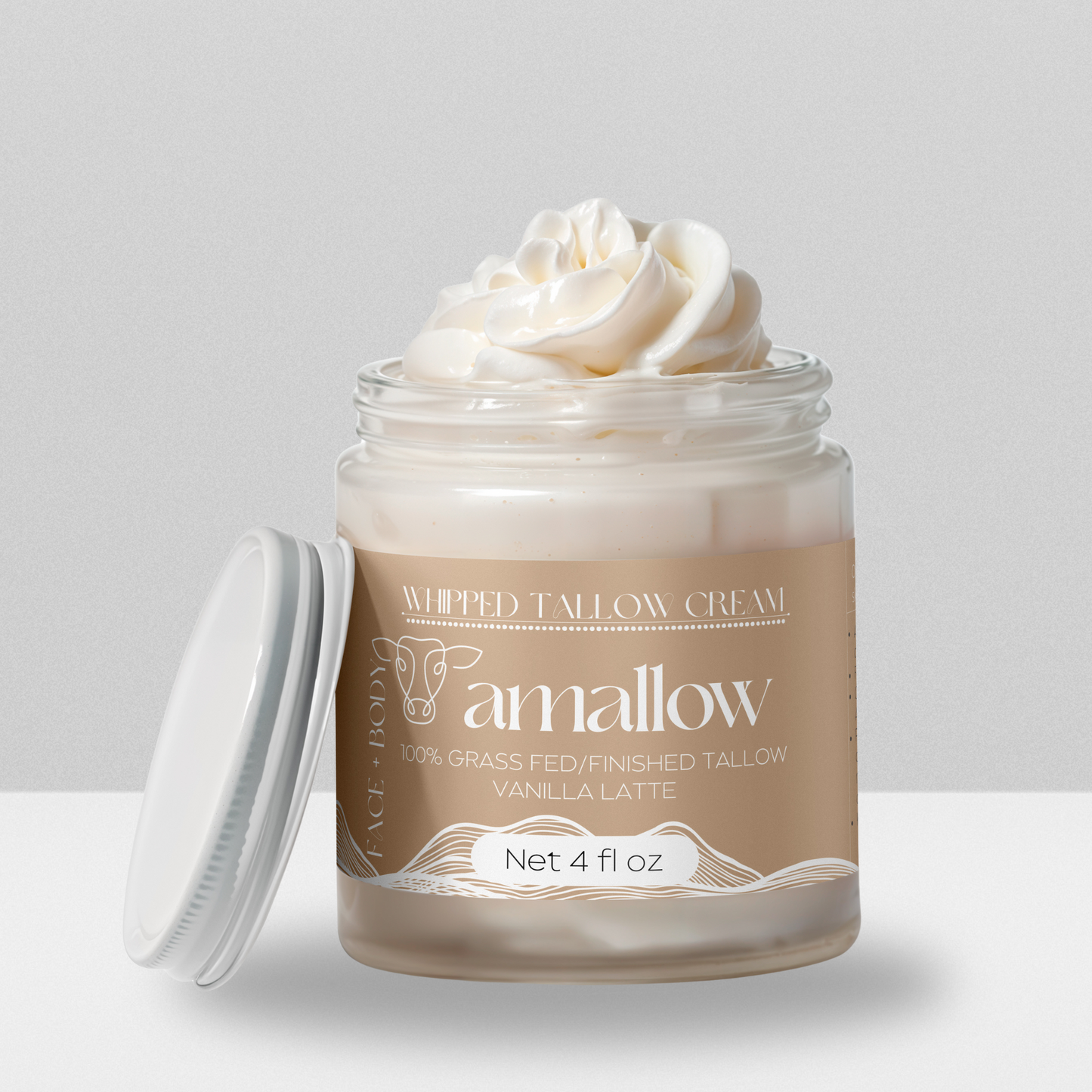 Vanilla Latte product shown with cream coming out the top. Label is a light brown color. Whipped Tallow Cream 100% grass fed/finished. Net 4 Fluid Oz. Face + Body.