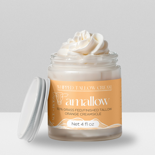 Orange Creamsicle product shown with cream coming out the top. Label is a light brown color. Whipped Tallow Cream  100% grass fed/finished. Net 4 Fluid Oz. Face + Body.