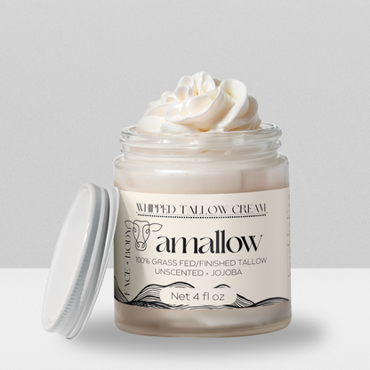 Unscented + Jojoba Oil product shown with cream coming out the top. Label is a cream color. Whipped Tallow Cream  100% grass fed/finished. Net 4 Fluid Oz. Face + Body.