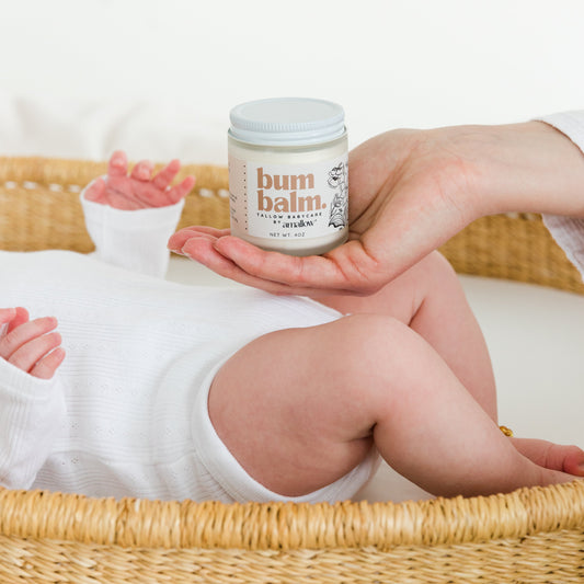 Mother holding amallow baby bum balm next to baby